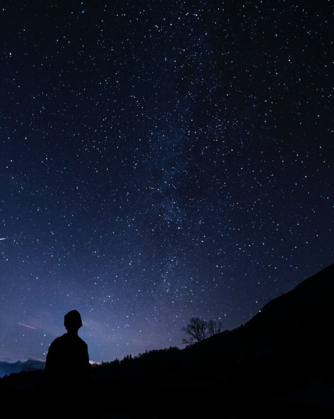 silhouette of man looking at stars
