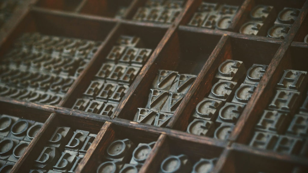 letter stamps organized in wooden shelf compartments